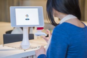 A woman uses facial recognition technology at a retail store to make the checkout process fast and convenient
