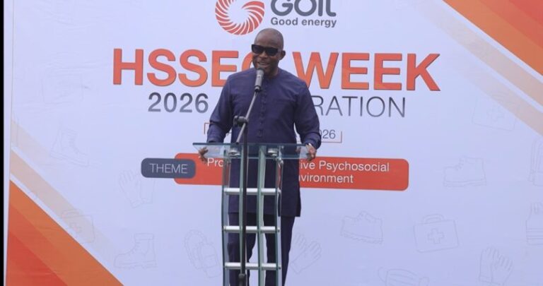 Man in a dark purple outfit speaks at a transparent podium on a stage, with a banner reading 'HSSE WEEK 2026' and the 'Goil Good energy' logo in the background.