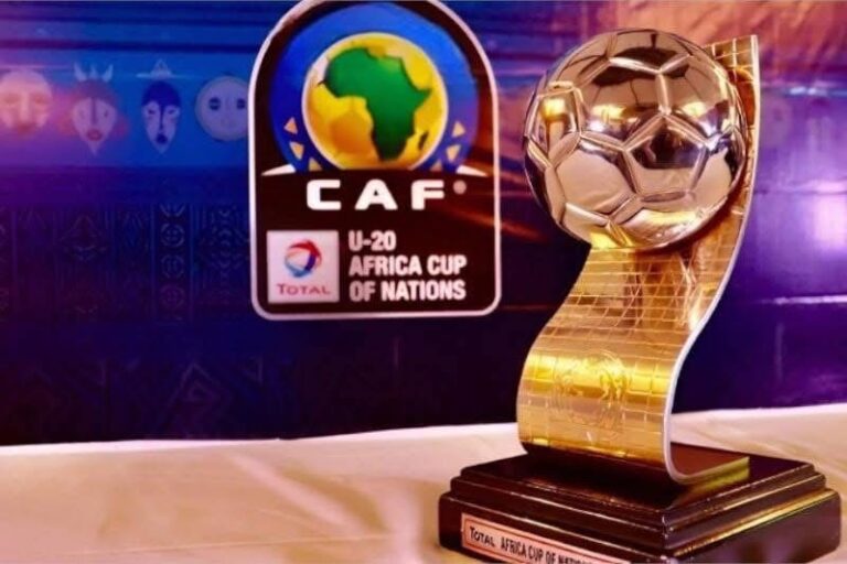 Golden Africa Cup of Nations trophy on a dark table with CAF U-20 branding in the background.
