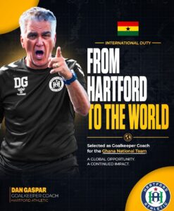 Portrait of a Hartford Athletic goalkeeper coach pointing toward the viewer, with bold text 'From Hartford to the World' and a Ghana flag in the upper right.