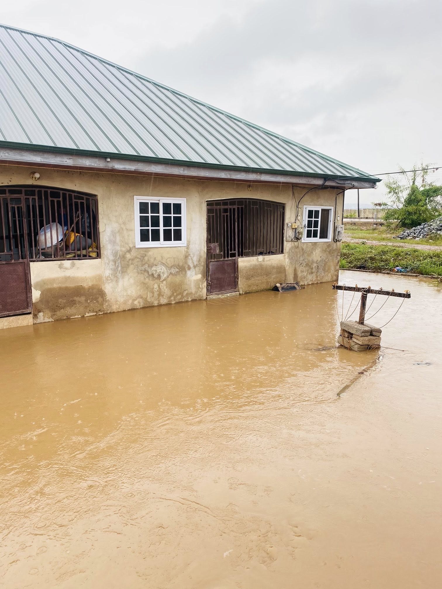 708345555_122173794446946649_4102212796657721548_n | Ghanaguardian.com Flooded single-story house with white-framed windows, a metal roof, and muddy water surrounding the walls.