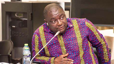 9252023103605-23041q5ddx-9252023101301-opoku | Ghanaguardian.com Man in a bright patterned shirt sits at a table in an office, looking to his right with a microphone in front.