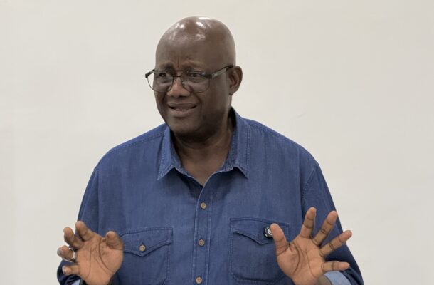 Afoko 2 | Ghanaguardian.com Man with glasses and a blue denim shirt gesturing with his hands while speaking, in mid-conversation.