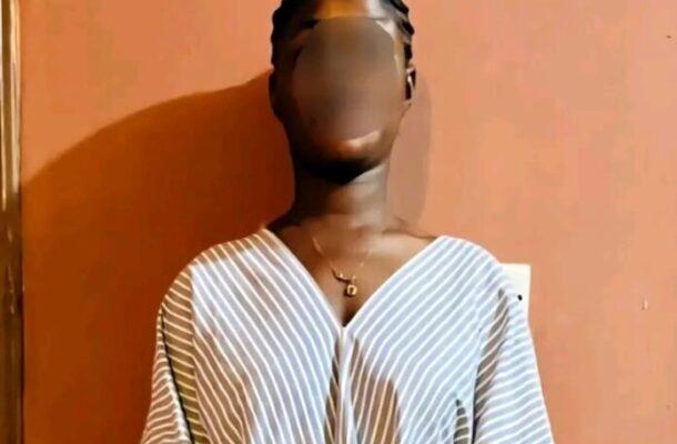 Aminat-Mahama-696x1090 | Ghanaguardian.com Person with braided hair wearing a striped V-neck top, standing against an orange wall; face blurred for privacy.
