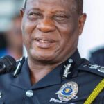 Senior police officer in uniform speaking into a microphone at a public event