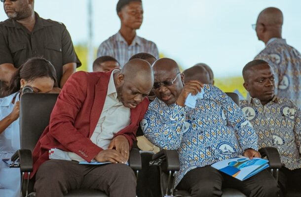 IMG-20260504-WA0011 | Ghanaguardian.com Two men in a red blazer and a patterned shirt lean over documents during an outdoor meeting.