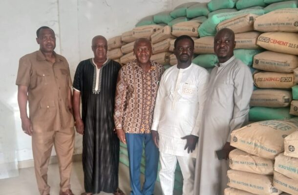 IMG-20260517-WA0002 | Ghanaguardian.com Five men stand side by side in a warehouse, with stacks of cement bags behind them.