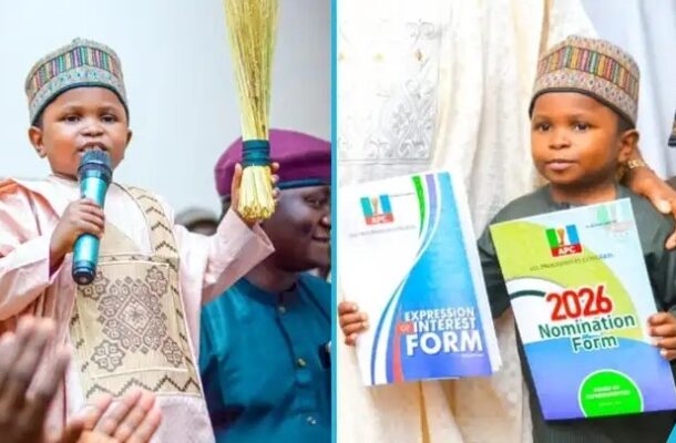 Two boys in traditional attire on stage; one speaks into a microphone, the other holds 2026 nomination and expression of interest forms.