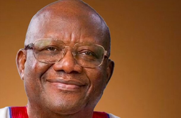 Close-up portrait of a smiling man wearing glasses against a brown background.