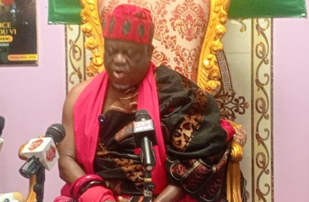 IMG-20260528-WA0016 | Ghanaguardian.com Elderly man in red and black traditional attire sits on an ornate gold chair, speaking at a press conference with multiple microphones in front.