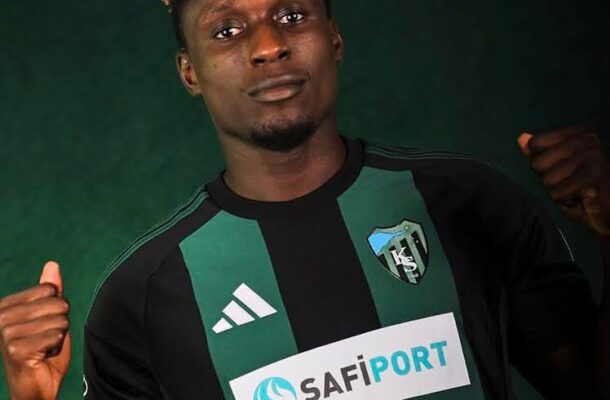 IMG_0408 | Ghanaguardian.com Portrait of a male footballer wearing a black and green striped jersey with SAFIPORT sponsor, fists raised in a confident pose.