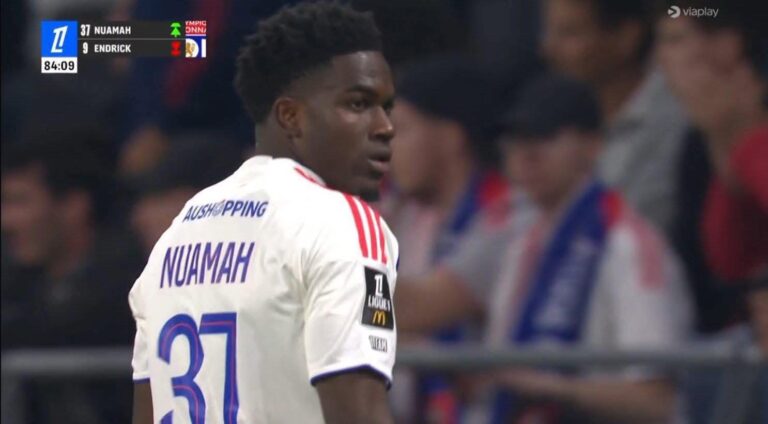 Soccer player Nuamah (number 31) in a white jersey, turning to look over his shoulder during a match with a stadium crowd in the background.
