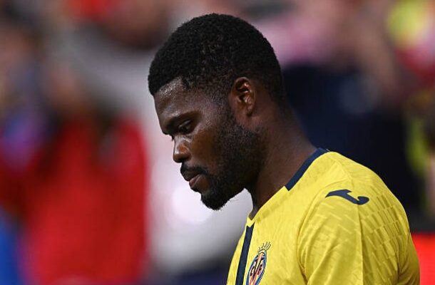 Side profile of a male footballer in a yellow jersey, looking down, on the field.