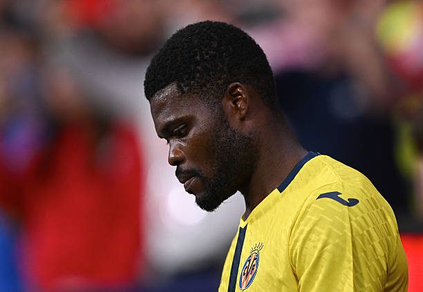 Side profile of a male footballer in a yellow jersey, looking down, on the field.