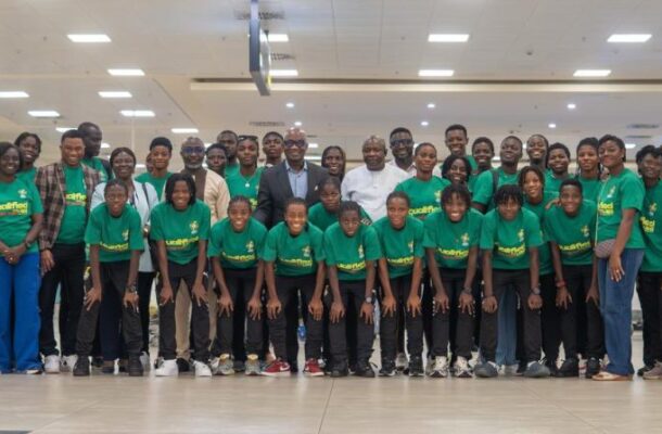 IMG_0526 | Ghanaguardian.com Large group photo of around 50 people wearing matching green t-shirts, posing together indoors in a spacious terminal or lobby area.
