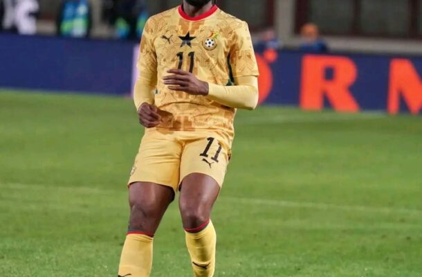 Soccer player in yellow kit with number 11 runs on a green field during a match.