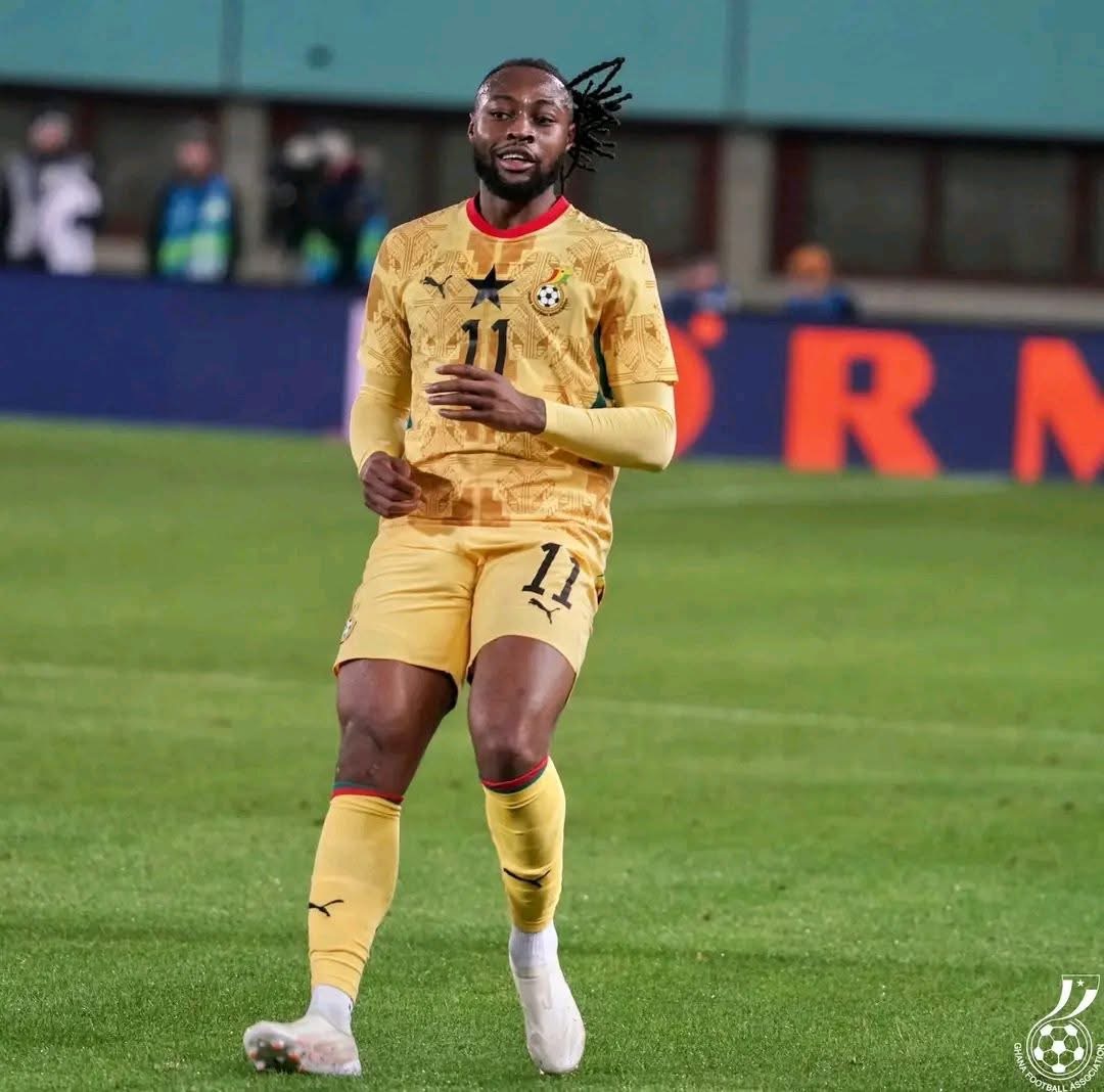Soccer player in yellow kit with number 11 runs on a green field during a match.