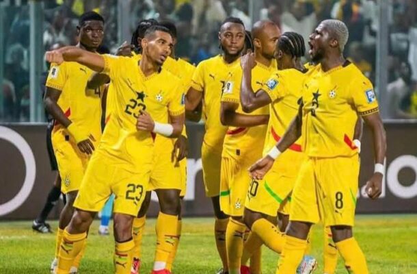 IMG_0621 | Ghanaguardian.com Soccer players in yellow uniforms celebrate on the field, group huddle with fans in the stadium behind.
