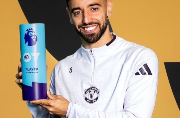 IMG_0647 | Ghanaguardian.com Male footballer in a Manchester United jersey holds a blue Premier League Player of the Season trophy and smiles at the camera.