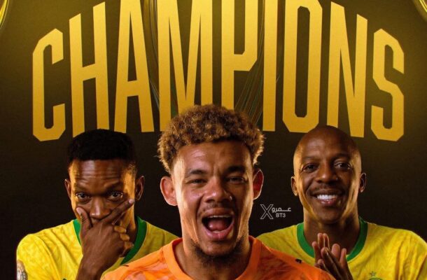 Three football players pose in front of a bold 'CHAMPIONS' poster with a golden trophy, celebrating victory; one wears an orange jersey in front, flanked by two players in yellow jerseys.