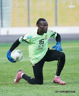IMG_0750 | Ghanaguardian.com Soccer goalkeeper in a lime green jersey with number 16 kneels on the field, holding a ball in one hand, wearing blue gloves and pink cleats.