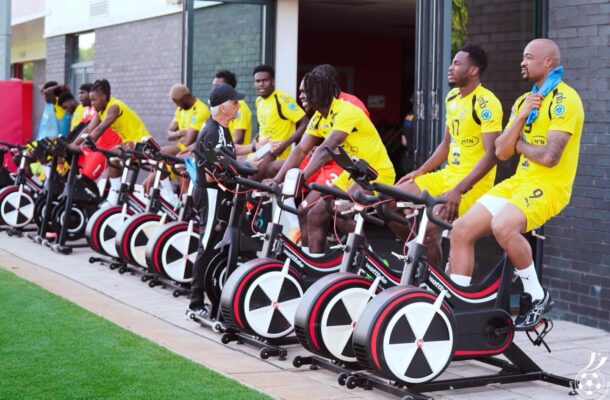 IMG_0755 | Ghanaguardian.com Group of athletes in yellow uniforms sit on black and red stationary bikes lined up outside a building outside a gym entrance.