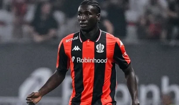 Soccer player in a red-and-black striped jersey with Robinhood sponsor, running on the field during a match.