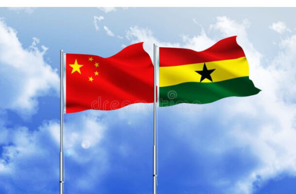 China and Ghana flags fluttering side by side against a clear blue sky with wispy clouds, mounted on flagpoles.