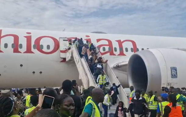 SA returnee | Ghanaguardian.com Crowd of passengers and ground crew in high-visibility vests boarding an Ethiopian Airlines plane via mobile stairs on the tarmac.