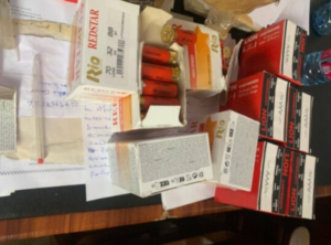 Cluttered desk with assorted medicine boxes and blister packs; colors red and white dominate, with some pills visible.