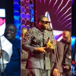 Three award winners on stage: left a woman in a white gown holding a star trophy at the mic, center a man in a suit accepting an award, right a woman in a gold dress holding a trophy.