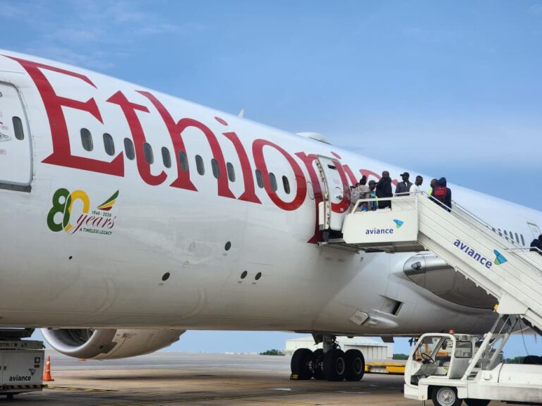 Passengers boarding an Ethiopian Airlines aircraft via mobile stairs labeled Aviance on a sunny tarmac.