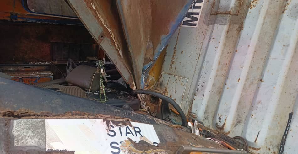 Interior of a rusted, crushed metal container filled with debris and scraps, conveying a scene of decay and abandonment.