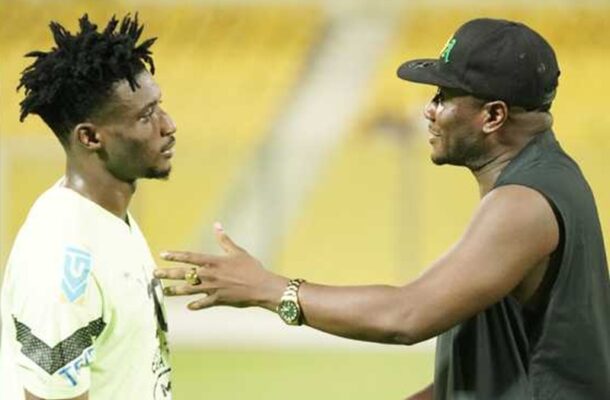 gyan | Ghanaguardian.com Two men stand face to face on a sports field, appearing to talk or argue during a game. One wears a white jersey; the other a black sleeveless shirt and cap.