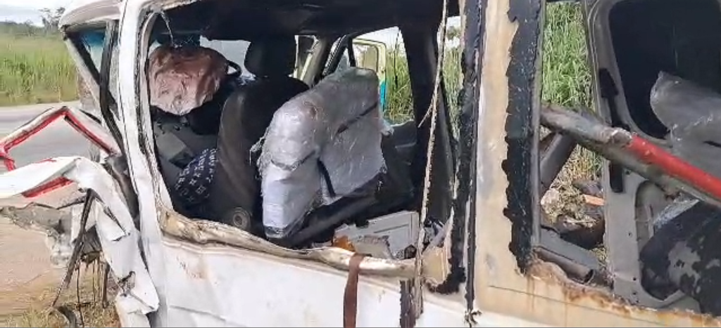 severely burnt, wrecked vehicle with charred interior and exposed seats after a crash; broken windows and debris inside