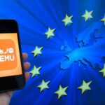 Hand holding a smartphone displaying the TEMU app logo against a blue background with EU stars and a Europe map motif