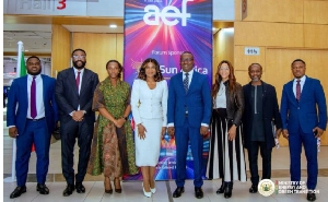 Eight professionals in formal attire pose for a group photo at a conference, with an AEF banner in the background.