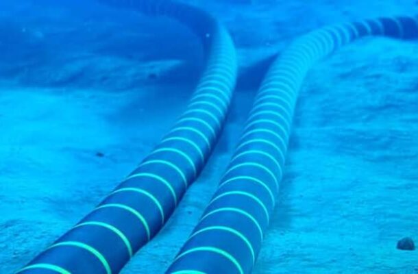 Two blue-striped hoses lie on a sandy pool floor underwater, curving away into the distance.