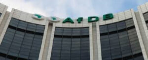 Front view of a curved glass-front building with large green 'AFDB' lettering on the top edge, signifying the African Development Bank.