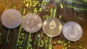 Four cryptocurrency coins—Bitcoin, Ethereum, and two others—laid on a green circuit board.