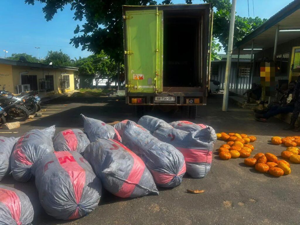 ADA-narcotics-1-1024x768 | Ghanaguardian.com Delivery scene: a green truck with its rear doors open in a parking lot, with gray bags tied with pink bands in the foreground and orange pumpkins to the right of the bags.