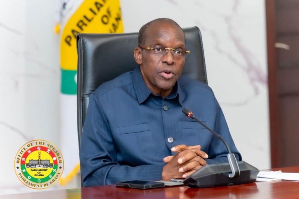 Bagbin 11 | Ghanaguardian.com Ghanaian official seated at a desk, speaking into a microphone during a formal briefing; Parliament seal visible in the background.