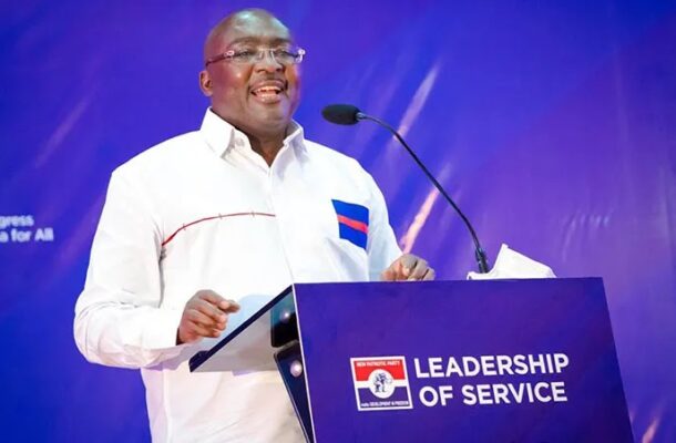 Bawumia-3 | Ghanaguardian.com Man in a white shirt delivering a speech at a lectern with a blue banner reading 'Leadership of Service' on stage with a microphone nearby