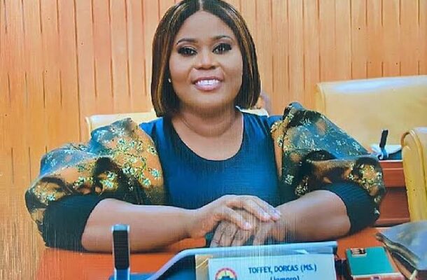 Dorcas Affo-Toffey | Ghanaguardian.com Smiling woman seated at a desk in an office, wearing a blue top with gold puff sleeves; nameplate on the desk reads "Toffey, Dorcas (Ms.)".