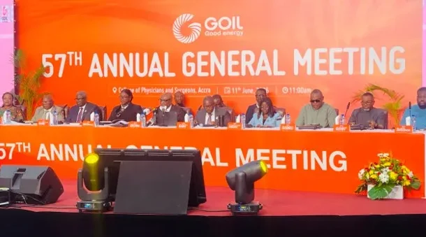 GOIL-lifts-profit-7-despite-lower-revenue | Ghanaguardian.com Panel of dignitaries seated at a long orange table on stage during GOIL 57th Annual General Meeting, with a bright orange backdrop and flower arrangement.