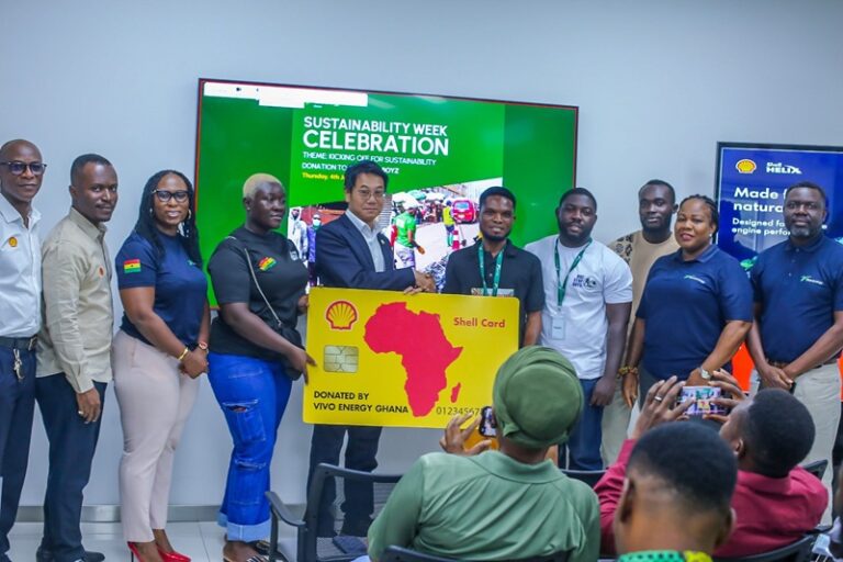 Group of people at a sustainability event presenting a oversized Shell card donation to Vivo Energy Ghana staff and attendees in a conference room. Same banner reads 'Sustainability Week Celebration'.