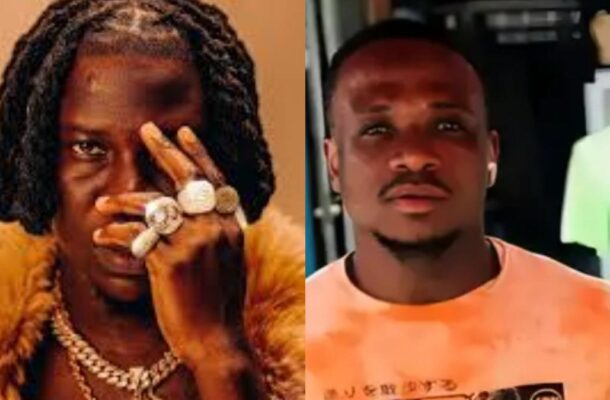 Two men side by side; left: rapper with dreadlocks, oversized rings, and fur coat covering one eye; right: man in a peach tie-dye shirt looking at the camera.