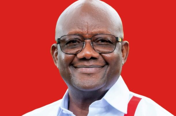 Smiling man wearing glasses and a white shirt with red suspenders against a solid red background, head-and-shoulders portrait.