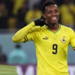Soccer player in a yellow Ghana national team jersey with number 9 celebrating on the pitch.