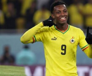 Soccer player in a yellow Ghana national team jersey with number 9 celebrating on the pitch.